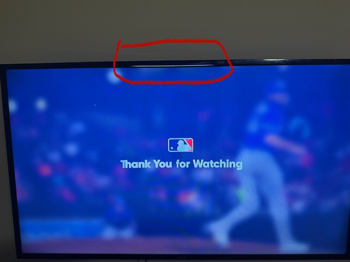 The smaller TV powered on, showing screen damage along the top edge of the panel, circled in red, visible as a dark distorted band across the displayed picture